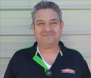 Gustavo wearing his black SERVPRO shirt smiling. 