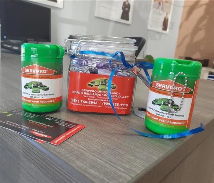 Candy jar and sanitizing canister with business cards on a desk. 